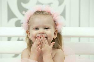 portret van een weinig vrolijk meisje met roze bogen. twee jaar oud kind. foto