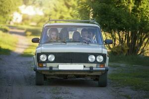 een vrolijk bedrijf zit in de oud auto. leven in de jaren 90. foto