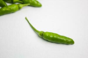 een stapel van groen Chili paprika's Aan een wit achtergrond foto