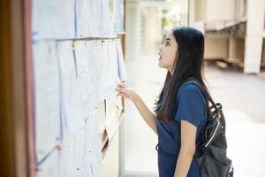 een vrouwelijke universiteitsstudent is spannend met het examenverslag foto