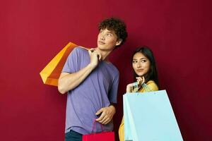 tieners kleurrijk Tassen boodschappen doen pret rood achtergrond ongewijzigd foto