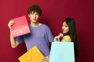 jong jongen en meisje kleurrijk Tassen boodschappen doen pret geïsoleerd achtergrond ongewijzigd foto