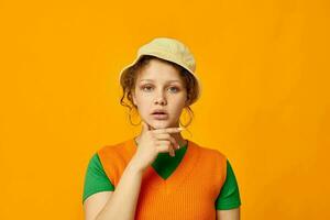 schattig meisje vervelend hoed poseren oranje trui geïsoleerd achtergrond foto