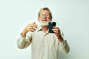 senior grijs haar Mens in een overhemd en bril een zwart glas geïsoleerd achtergrond foto