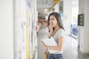 een vrouwelijke universiteitsstudent is spannend met het examenverslag foto