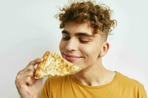 knap vent aan het eten pizza poseren detailopname licht achtergrond foto