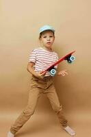 schattig meisje skateboard in hand- poseren baby kleren pret geïsoleerd achtergrond foto