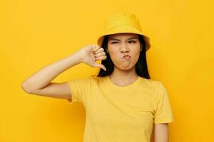 charmant jong Aziatisch vrouw vervelend een geel hoed poseren emoties geel achtergrond ongewijzigd foto