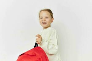mooi jong meisje school- rood rugzak poseren geïsoleerd achtergrond foto