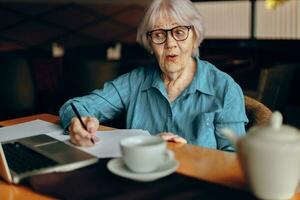 gelukkig senior vrouw werken in voorkant van laptop toezicht houden op zittend levensstijl ongewijzigd foto