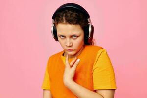 mooi vrouw hoofdtelefoons muziek- mode poseren roze achtergrond ongewijzigd foto