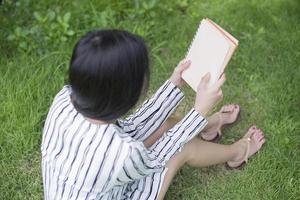 aantrekkelijke vrouw die een boek in het park leest foto