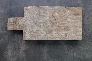 lege vintage houten snijplank opgezet op donkere betonnen achtergrond met kopie ruimte foto