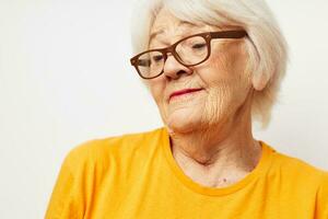 emotioneel ouderen vrouw in gewoontjes t-shirt en bril licht achtergrond foto