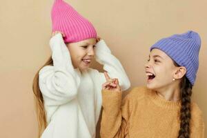 twee weinig meisjes zijn staand De volgende naar elk andere in hoeden mode emoties foto