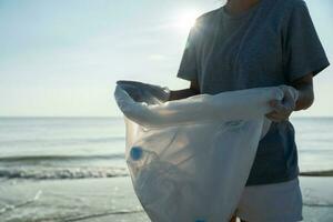opslaan oceaan. vrijwilliger plukken omhoog uitschot vuilnis Bij de strand en plastic flessen zijn moeilijk ontleden voorkomen kwaad aquatisch leven. aarde, omgeving, vergroening planeet, verminderen globaal opwarming, opslaan wereld foto