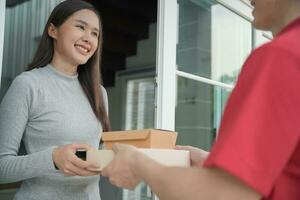 gelukkig glimlachen vrouw ontvangt dozen pakket van koerier in voorkant huis. levering Mens sturen leveren uitdrukken. online winkelen, papier containers, afhalen, postbode, levering onderhoud, pakketjes foto