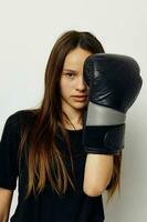 jong mooi vrouw in boksen handschoenen stempel in zwart broek en een t-shirt levensstijl ongewijzigd foto