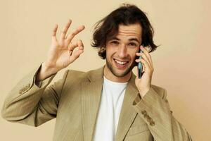 Mens communicatie door telefoon beige pak elegant stijl geïsoleerd achtergrond foto