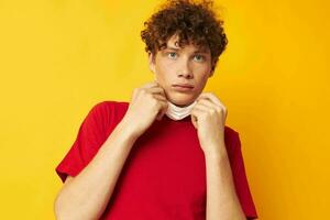 vent met rood gekruld haar- in een rood t-shirt medisch masker bescherming levensstijl ongewijzigd foto