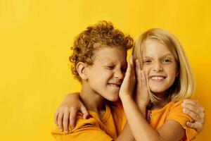 portret van schattig kinderen knuffelen mode kinderjaren vermaak Aan gekleurde achtergrond foto