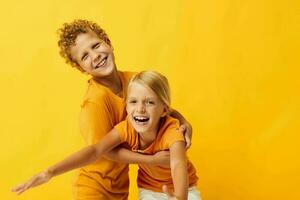 schattig elegant kinderen in geel t-shirts staand kant door kant kinderjaren emoties geïsoleerd achtergrond ongewijzigd foto