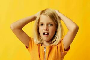 schattig weinig meisje met blond haar- poseren geel achtergrond foto