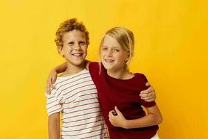 portret van schattig kinderen knuffelen mode kinderjaren vermaak Aan gekleurde achtergrond foto