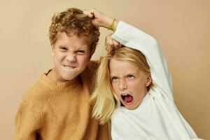 weinig jongen en meisje staand De volgende naar poseren emoties geïsoleerd achtergrond foto