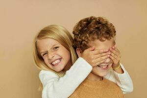 schattig elegant kinderen knuffel vermaak poseren vriendschap beige achtergrond foto