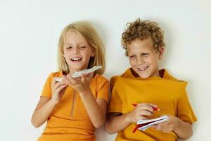 jongen en meisje liggen Aan de verdieping met blocnotes en potloden kinderjaren levensstijl ongewijzigd foto