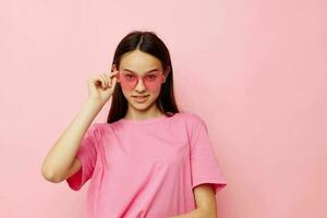 mooi vrouw in een roze t-shirt gewoontjes kleren roze achtergrond foto