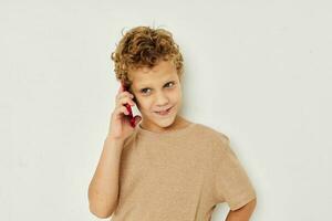 vrolijk schattig jongen met telefoon in handen poseren technologie foto