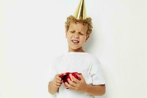 schattig jongen met een pet Aan zijn hoofd een geschenk doos in de vorm van een hart foto