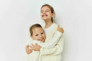 twee weinig meisjes in truien poseren vriendschap pret foto