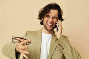 Mens communicatie door telefoon beige pak elegant stijl geïsoleerd achtergrond foto