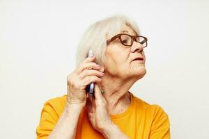 foto van gepensioneerd oud dame in modieus bril met een smartphone in hand- detailopname emoties