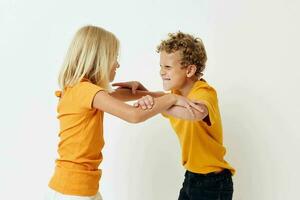 portret van schattig kinderen in geel t-shirts staand kant door kant kinderjaren emoties ongewijzigd foto