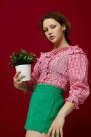 jong vrouw in roze blouse is poseren met een fabriek in wit pot detailopname foto