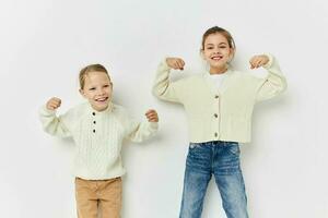 twee weinig meisjes vriendinnetjes poseren licht achtergrond foto