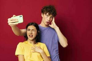 jong Mens en meisje in kleurrijk t-shirts met een telefoon jeugd stijl foto