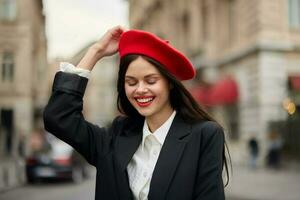 mode vrouw portret glimlach met tanden staand Aan de straat in voorkant van de stad toerist in elegant kleren met rood lippen en rood baret, reis, filmische kleur, retro wijnoogst stijl, stedelijk mode. foto