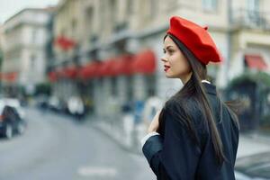 mode vrouw portret schoonheid staand Aan de straat in voorkant van de stad in elegant kleren met rood lippen en rood baret, reis, filmische kleur, retro wijnoogst stijl, stedelijk mode levensstijl. foto