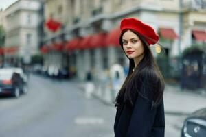 mode vrouw portret schoonheid staand Aan de straat in voorkant van de stad in elegant kleren met rood lippen en rood baret, reis, filmische kleur, retro wijnoogst stijl, stedelijk mode levensstijl. foto