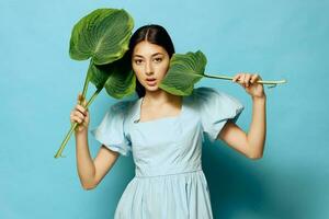 vrouw kunstmatig studio blauw blad aantrekkingskracht glimlach jong schoonheid palm roze foto