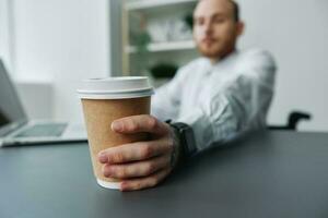 een Mens in een rolstoel, een zakenman met tatoeages in de kantoor Bij een laptop, een koffie pauze, de concept van werken een persoon met handicap, vrijheid van sociaal kaders foto