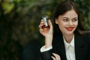 vrouw glimlach met tanden drinken thee in een cafe van een Turks glas mok Aan de straat foto