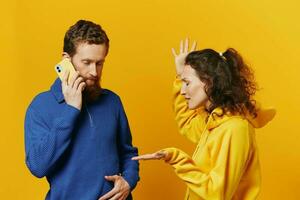 Mens en vrouw paar met telefoon in hand- telefoontje pratend Aan de telefoon, Aan een geel achtergrond, symbolen tekens en hand- gebaren, familie ruzie jaloezie en schandaal. foto