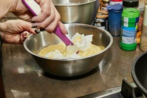 chef in de huis keuken mengsels gepureerd aardappelen met verzuren room foto