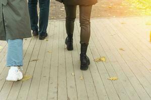 vrouwen poten in leer broek en laarzen wandelen tussen menigte van voorbijgangers foto